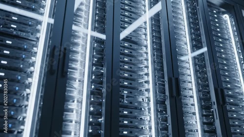 Blue lit data storage infrastructure aisle with tall glass server cabinets, dense rack hardware, bright vertical light strips, layered network equipment, and secure enterprise cloud facility