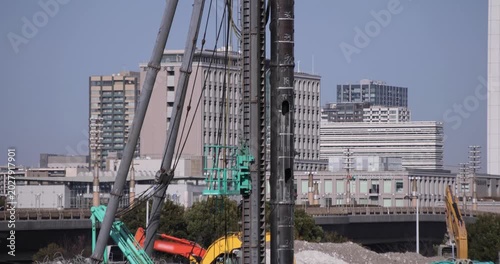 Moving cranes at the under construction in Tokyo in winter telephoto shot tilt up