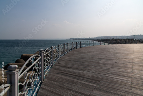 Curved wooden boardwalk path at Mukho port waterfront park