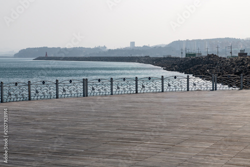 Coastal wooden deck viewpoint looking at breakwater in Mukho
