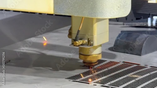 Laser cutting machine carving patterns on metal sheet with bright sparks
