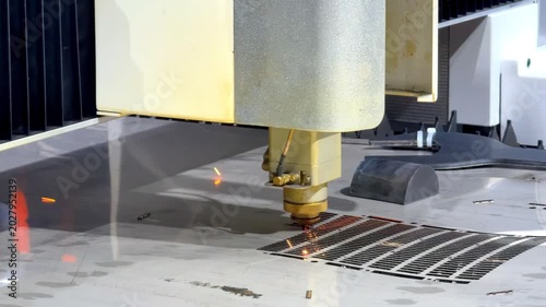 Industrial CNC laser cutter processing steel plate in metalworking factory.
