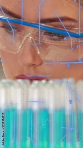 Vertical video: Scientist scanning test tubes in lab, gaze activating HUD, analyzing samples