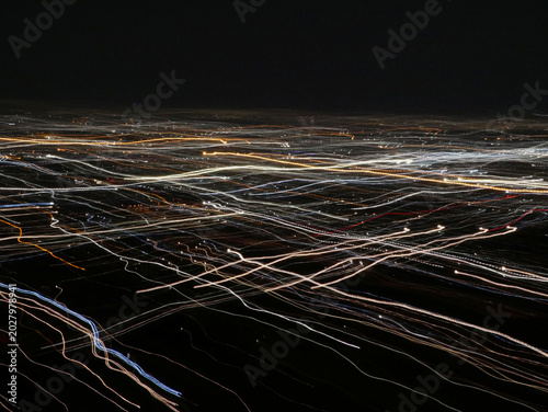 abstract mixture of parallel light tracks of a city crossing by a double exposure