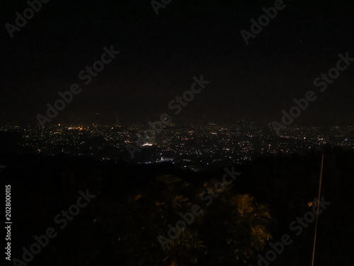Tableau sur toile Stunning panoramic nightscape of a vast city illuminated under the dark sky and Beautiful scenic view of glowing city lights twinkling in the dark night