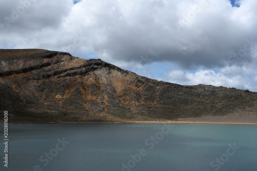 Volcanic Crater Lake with Turquoise Water and Sloping Mineral-Rich Ridges