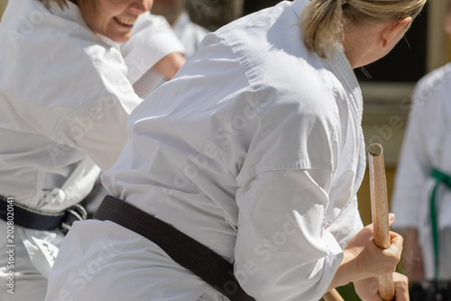 Konstfotografi A karateka in a white kimono with a black belt throws punches.