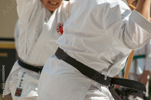 Cuadro en lienzo A karateka in a white kimono with a black belt throws punches.
