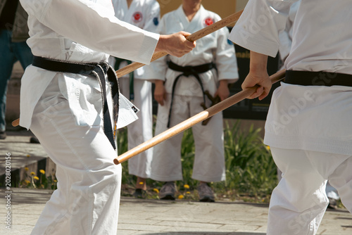 Foto A karateka in a white kimono with a black belt throws punches.