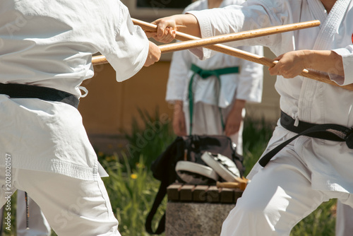 Bild auf Leinwand A karateka in a white kimono with a black belt throws punches.