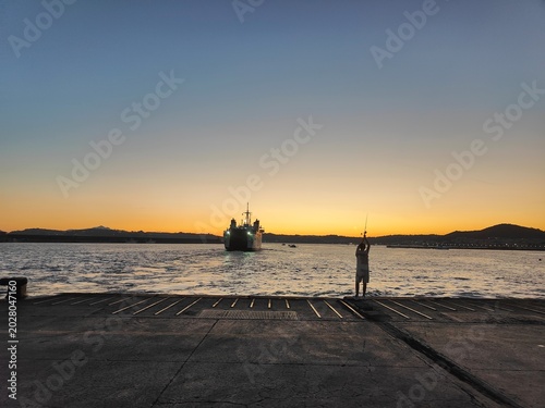 Tableau sur toile Fisherman Silhouette Casting Rod Ferry Arriving Pozzuoli Harbour Sunset Naples