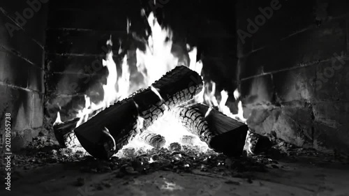 Cozy fireplace with burning logs and chair in monochrome creating a relaxing environment perfect for winter