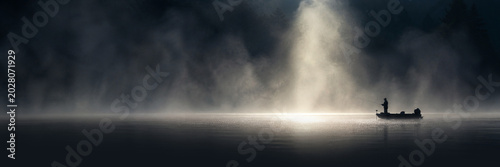 Fisherman Boat Silhouette on Misty Lake With Dramatic Morning Light