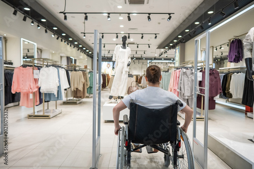 A Caucasian woman in a wheelchair shopping at a mall. 