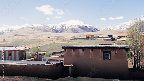 Foto A peaceful Tibetan village lies at the base of Garze’s snow-capped mountains in Sichuan