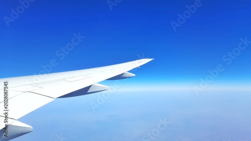 Airplane wing in flight above clouds