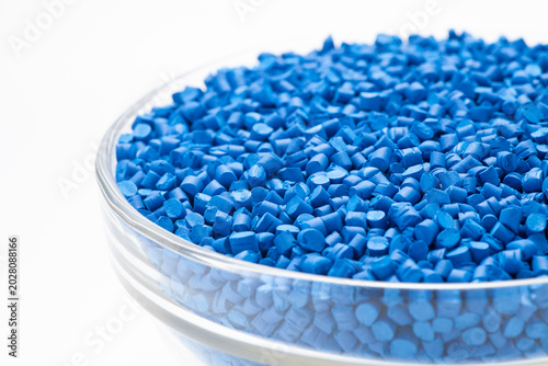 Blue masterbatch granules in a glass bowl. Masterbatch is a new type of colorant specifically for polymer materials