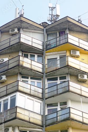 Fotografi Upper apartment building levels with serrated balcony and dense rooftop utility infrastructure