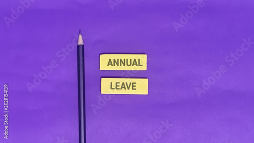 Annual leave concept with a pencil and two yellow text boxes on a purple background, representing vacation and time off