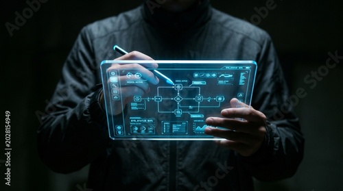 A man interacts with a futuristic digital tablet displaying blue graphics in a dark room.