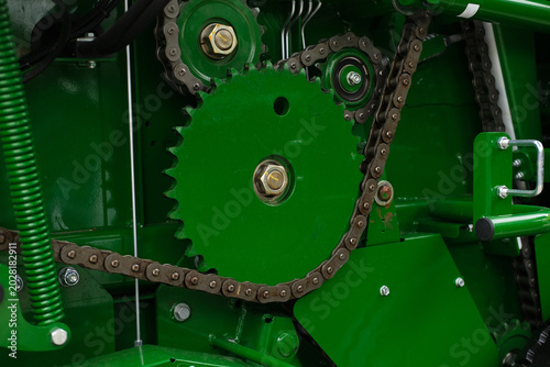 Industrial machine with green gears and chains in close up, showcasing mechanical drive components, engineering precision, and manufacturing efficiency