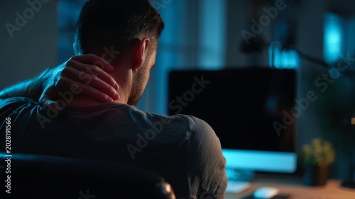 Man sits in dimly lit office at night