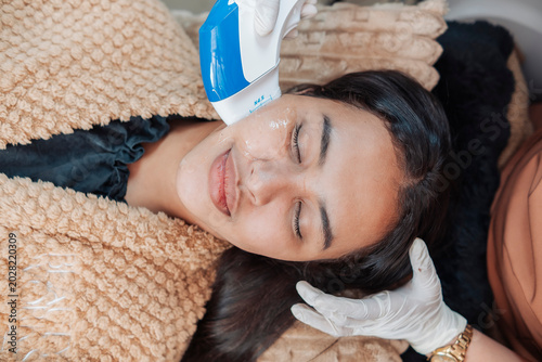 Fotografie Female patient receiving HIFU treatment at an aesthetic clinic for jawline lifti