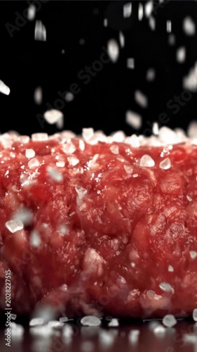 The cook sprinkles salt on the meat burger. Filmed on a high-speed camera at 1000 fps. High quality FullHD footage