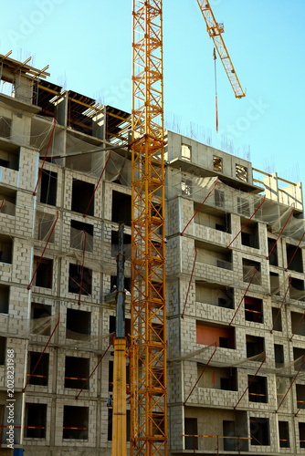 Slika na platnu Monolithic concrete building framework during construction phase with hoisting crane