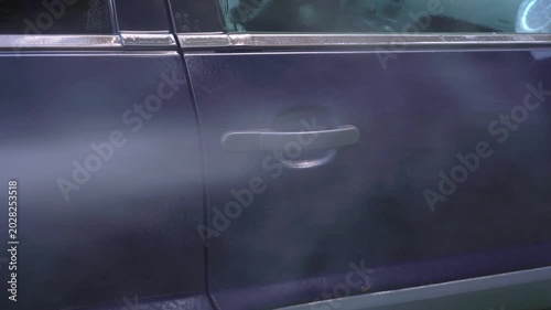 Washing handle door of car with pressure washer outdoors. High pressure car wash. Car wash