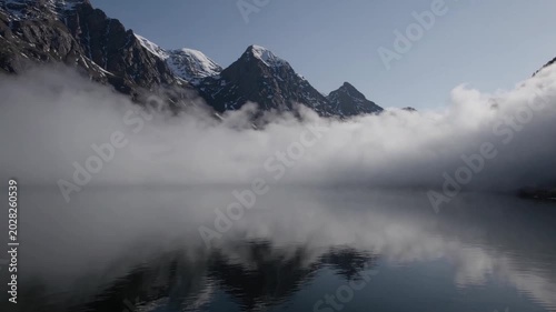 Majestic Mountain Landscape with Reflection in Calm Lake and Misty Atmosphere