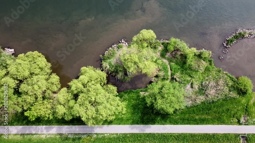 Drohne fliegt über Fluss mit Auwald im Frühling, Uferschutz, Biodiversität, Luftaufnahme