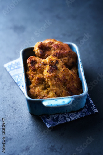 Fried chicken breast on a stone background. Soft focus.