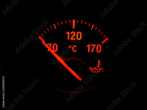 Red fuel gauge warning light showing low fuel level on a dark background, symbolizing empty tank, fuel shortage, and energy crisis.