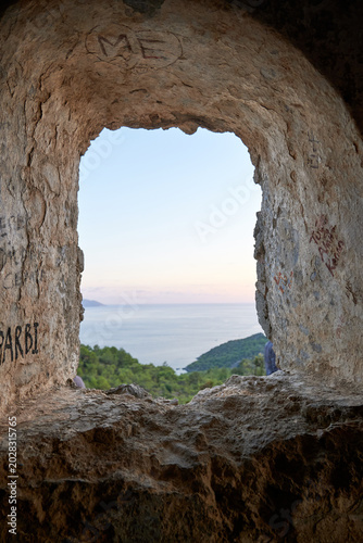 Beautiful sea landscape viewed through the frame of an arched ruined stone window