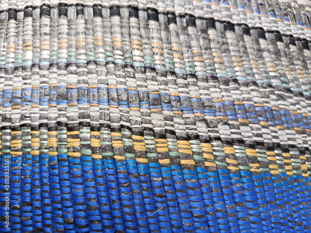 Naklejka premium Macro Texture of a Colorful Woven Synthetic Mat with Vibrant Blue and Yellow Stripes