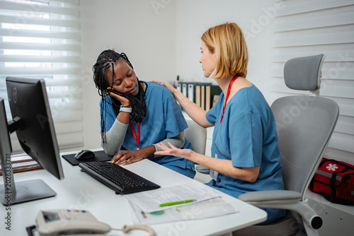 Φωτογραφία Nurse experiencing burnout feeling tired, coworker offering support