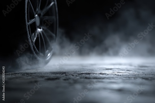 Car wheel spinning with smoke on a dark, wet road, dramatic low key lighting