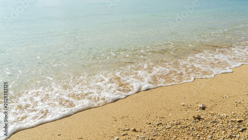 Konstfotografi Close up of white bubbly waves washing onto the sandy beach with clear emerald g