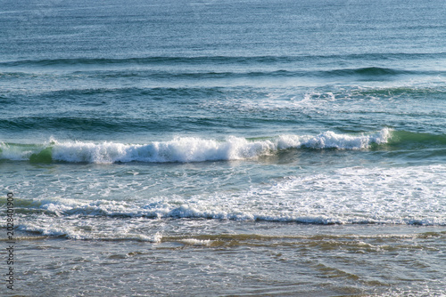 Foto Close up of ocean wave splashing on sandy shore