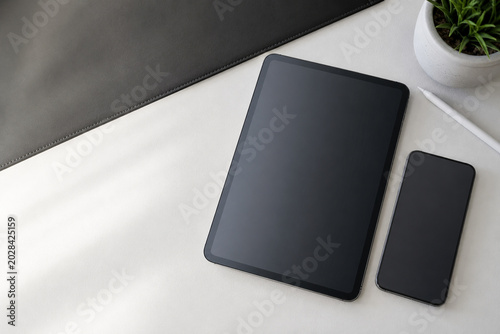 Modern digital workspace with tablet and smartphone on minimalist desk