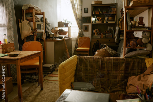 Quadro su tela Wide shot of cramped studio apartment showing compact kitchen, desk, sofa, storage shelves, conveying poverty and small space living