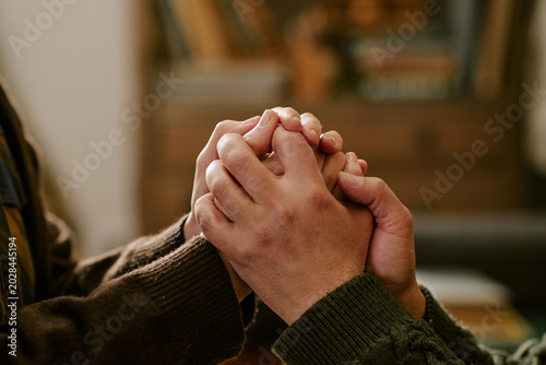 Photos Close up of young adult couple holding hands, expressing support during financial hardship and emotional stress