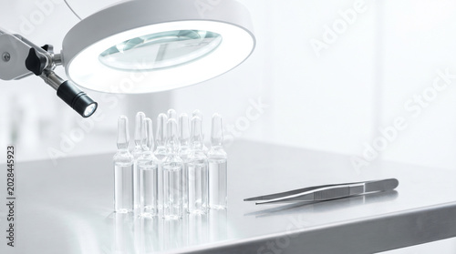 Medical Glass Ampoules under Magnifying Lamp for Quality Inspection in Sterile Laboratory
