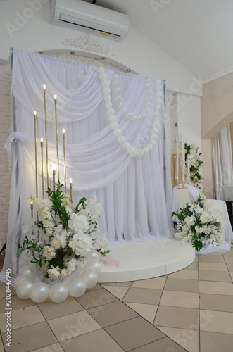 wedding photo zone made of white fabric with pearls and a candlestick