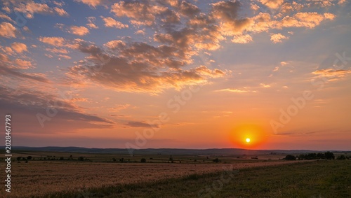 Beautiful sunset sky photo featuring warm golden hues, soft orange clouds, and a peaceful evening atmosphere. The stunning natural scenery captures the magical transition between day and night, creati