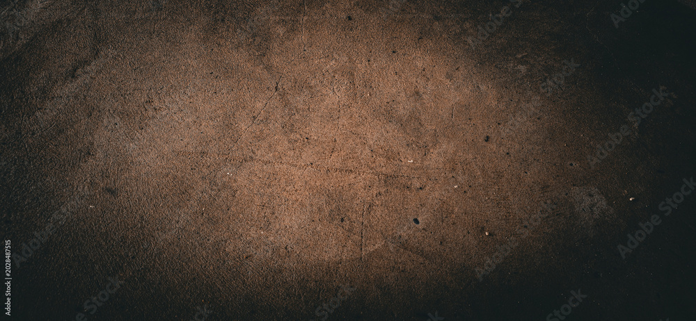 Fototapeta premium Dark, rustic abstract background with a textured, earthy surface and a moody, vignette-style lighting effect.