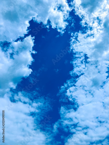 Bild auf Leinwand Bright blue sky with clouds forming patterns during midday in a clear atmosphere