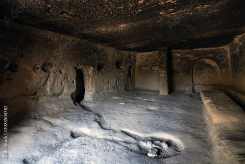 Interior view of a historic rock-cut cave room carved into volcanic tuff in Göreme, Cappadocia, Türkiye.