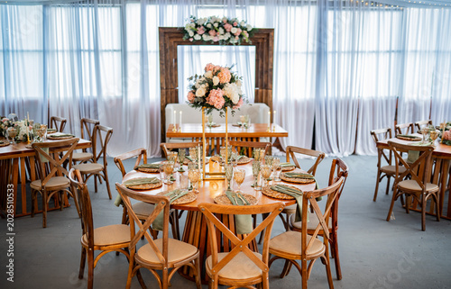Foto Elegante salón de recepción de bodas con mesas decoradas, arreglos florales y am